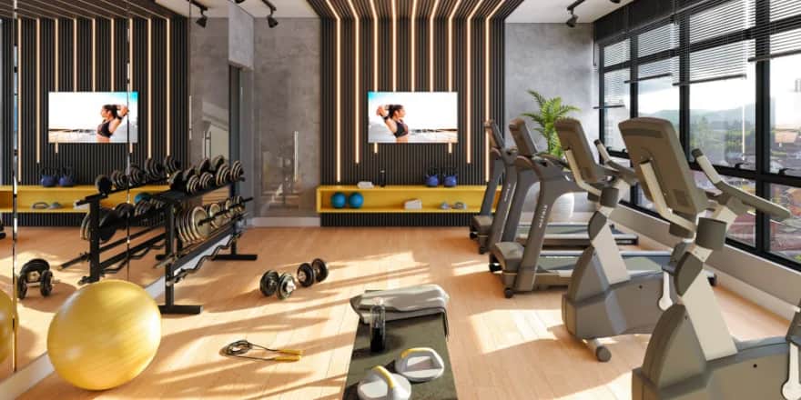 Modern gym with treadmills, stationary bikes, free weights, a yellow exercise ball, and large windows letting in natural light. Mirrors and wall TVs enhance the spacious, stylish interior with wood and black striped accents.